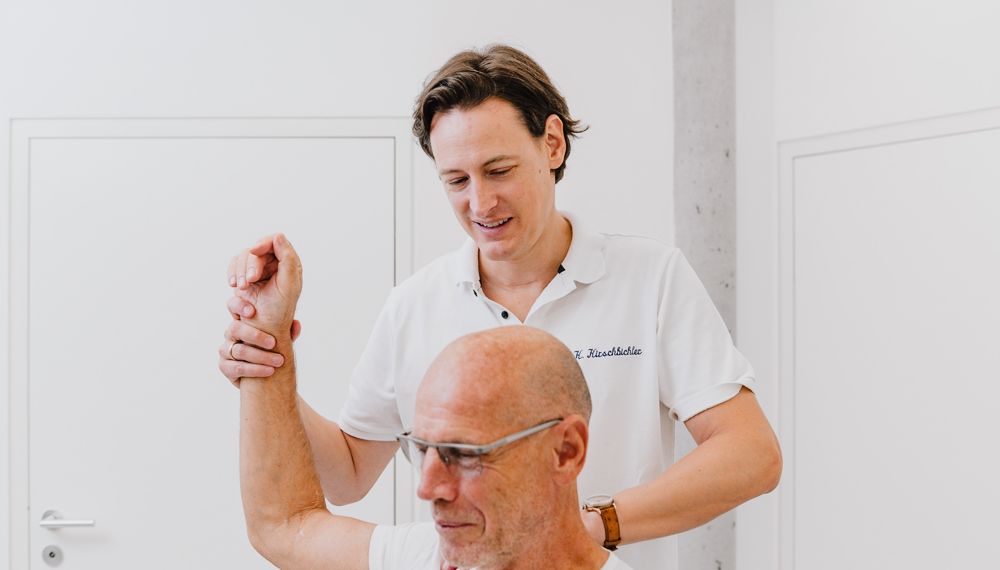 Dr. Kirschbichler untersucht die Schulter eines Patienten